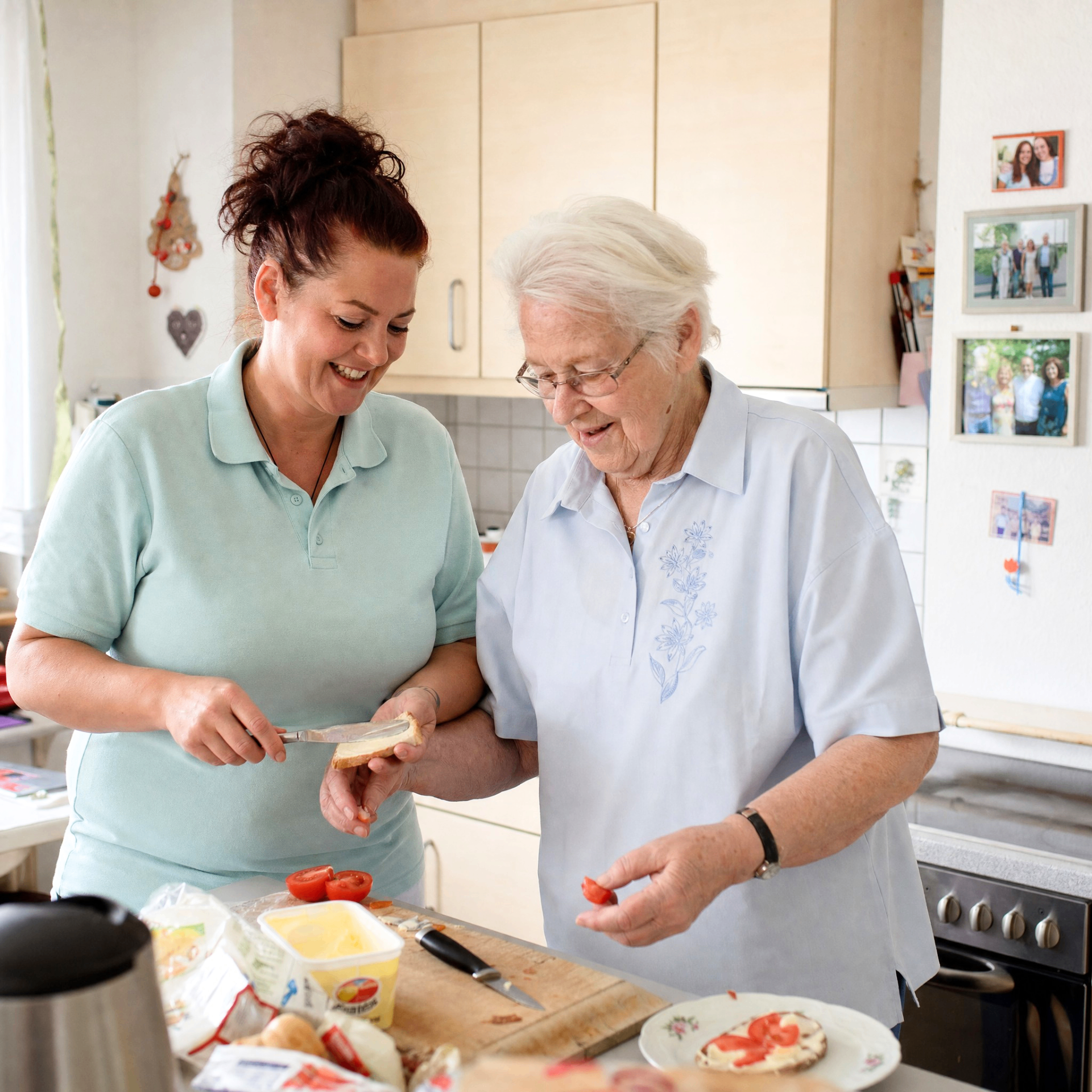 Betreuungskraft bereitet gemeinsam mit einer Seniorin das Frühstück zu